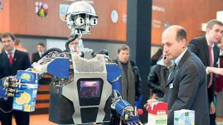 Diener und Meister: Roboter Armar hat den Saft schon in der Hand, den er Tamim Asfour bringen soll.