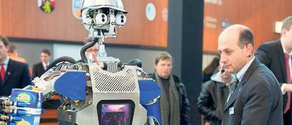 Diener und Meister: Roboter Armar hat den Saft schon in der Hand, den er Tamim Asfour bringen soll.