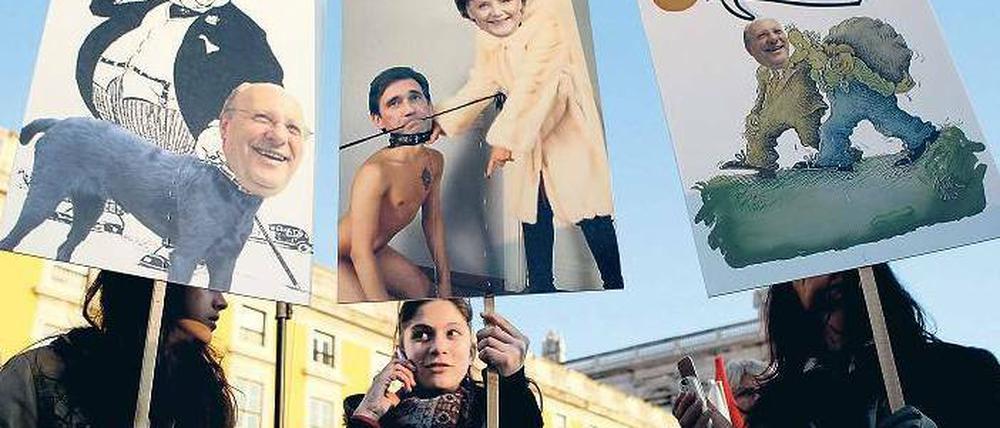 Wut: Demonstranten zeigen auf ihren Protesttafeln, in welchen Rollen sie die deutsche Bundeskanzlerin Angela Merkel und den portugiesischen Ministerpräsidenten Pedro Passos Coelho sehen. Foto: picture alliance/dpa