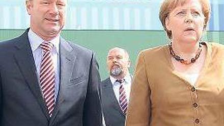 Schwerer Gang: Merkel besucht die Stralsunder Werft mit P+S-Chef Fuchs. Foto: dpa