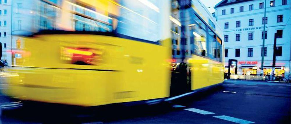Eine gelbe Berliner Straßenbahn fährt über den Rosenthaler Platz. 