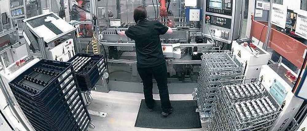 Mensch und Maschine. In der Produktionshalle des Marienfelder Mercedes-Werks kann man schon jetzt beobachten, was mit Industrie 4.0 gemeint ist. Beschäftigte und Roboter arbeiten bei der Produktion von Motoren und Komponenten eng zusammen – und sollen dies künftig noch enger tun. 