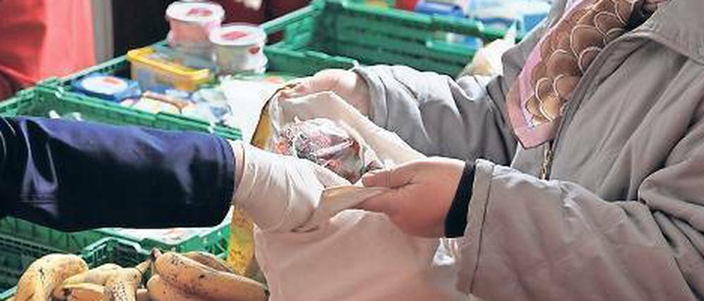 Eine Mitarbeiterin der Berliner Tafel versorgt Bedürftige mit Obst und Gemüse. 