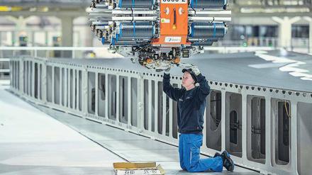 Fachkräfte in Sorge. Eine Airbus-Mitarbeiterin im niedersächsischen Stade arbeitet an einem Industrieroboter, der Tragflächen für den Airbus A350 herstellt. Foto: Axel Heimken/dpa