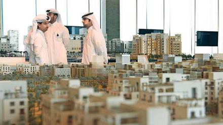 Kataris in Doha inspizieren ein Stadtmodell. In Deutschland suchte Katar bisher vor allem Baufirmen. Das ändert sich. 