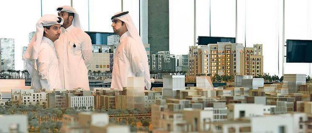 Kataris in Doha inspizieren ein Stadtmodell. In Deutschland suchte Katar bisher vor allem Baufirmen. Das ändert sich. 