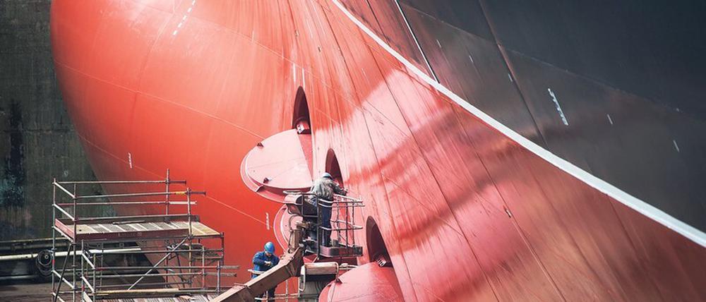 Schweißer und Schrauber arbeiten am Rumpf der „Queen Mary 2“ im Trockendock bei Blohm &amp; Voss in Hamburg. Der Schiffbau hat sich hierzulande in den vergangenen fünf Jahren prächtig entwickelt und bietet inzwischen mehr als 100 000 Arbeitsplätze an den Küsten und an der Ems. 