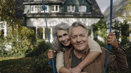 Portrait of a happy woman embracing senior man on a swing in garden model released Symbolfoto property released PUBLICATIONxINxGERxSUIxAUTxHUNxONLY GUSF03071