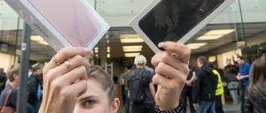 Frau mit neuen iPhones: Will Apple den Verkauf durch eine Leistungsbremse ankurbeln? 