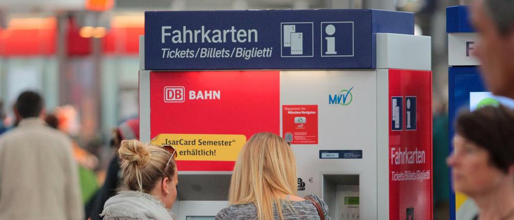 Zwei Frauen stehen an einem Fahrkartenautomat der Deutschen Bahn. 