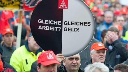Die Mitarbeiter von Mercedes Benz, die im November 2011 in Sindelfingen demonstrierten, hielten ein rundes Plakat mit der Aufschrift: "Gleiche Arbeit? Gleiches Geld!" in die Höhe.