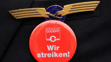 Ein Lufthansa-Pilot mit Streik-Button. Die Pilotenvereinigung Cockpit bestreikt am Dienstag zunächst Langstreckenflüge.