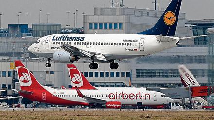 Eine Boeing 737 der Lufthansa am Flughafen Düsseldorf - wo Air Berlin ein Drehkreuz betreibt. Im Hintergrund stehen Flugzeuge der Fluggesellschaft Air Berlin.