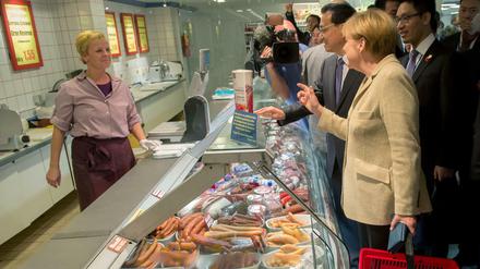 Bundeskanzlerin Angela Merkel kauft ein. An ihrer Seite: der chinesische Ministerpräsident Li Keqiang, geschehen am 10. Oktober 2014 im Verbrauchermarkt an der Mohrenstraße. 