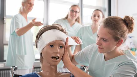 Pflegeschülerinnen lernen das Anlegen eines Kopfverbandes im Klinikum Stuttgart. 
