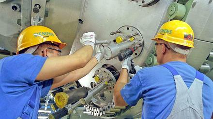 Gebaut in Moabit. Zwei Siemens-Mitarbeiter montieren Gasbrenner im Werk in der Huttenstraße. Künftig sollen die Gasturbinen noch effizienter werden. Die Arbeit daran findet ab Oktober 2014 in Ludwigsfelde statt. 