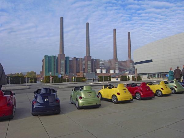 Kein Spiel. Eine Reihe von Spielzeugautos auf einem Parkplatz vor der VW-Fabrik in Wolfsburg. 