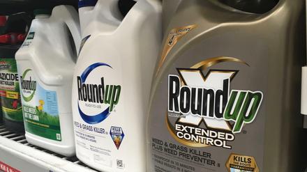 Behälter mit dem Unkrautvernichter Roundup stehen in einem Verkaufsregal