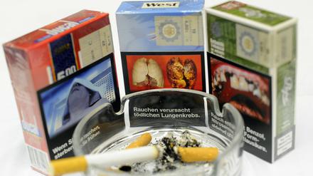 Zigarettenschachteln mit Aufdrücken von Folgeschäden des Zigarettenkonsums .