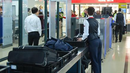 Passagiere und ihr Handgepäck werden bei einer Sicherheitskontrolle im Flughafen Tegel kontrolliert. 