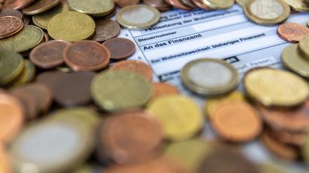 Ein Formular zur Steuererklärung ist von Euro-Münzen bedeckt. 