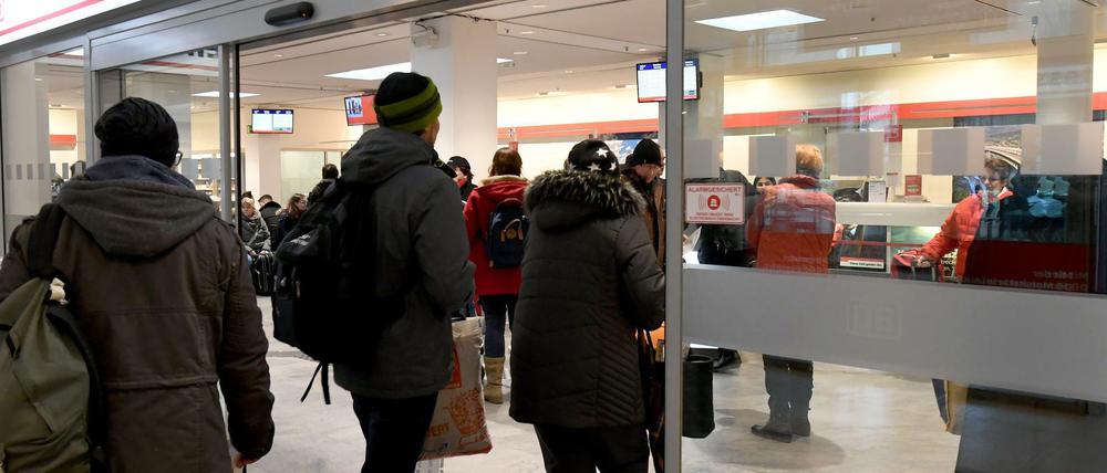 Reisende betreten das Reisezentrum der Bundesbahn. 