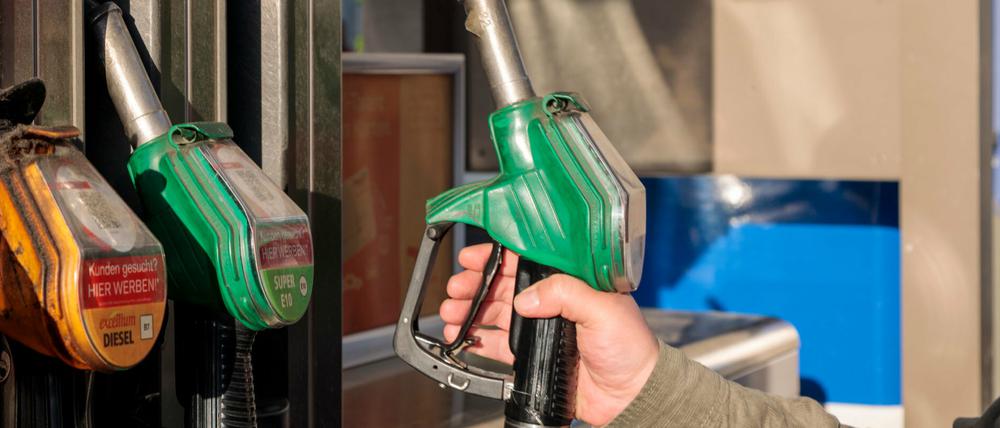 Ein Mann tankt an einer Tankstelle Benzin von Total. 