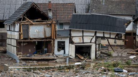 Schutt liegt in dem Ort im Kreis Ahrweiler nach dem Unwetter mit Hochwasser vor einem beschädigten Gebäude.