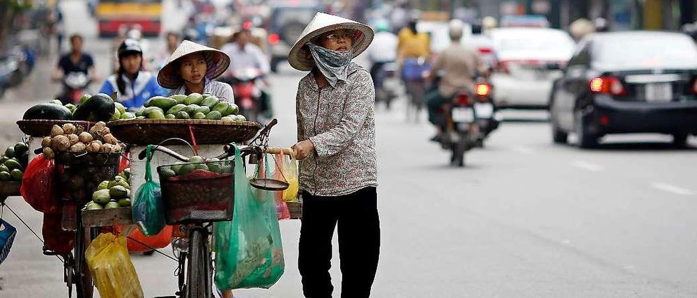 Händlerinnen auf einer Straße in Hanoi. Trotz Wirtschaftsboom ist das Einkommen in Vietnam sehr ungleich verteilt. Vor allem die Menschen auf dem Land haben zu kämpfen.