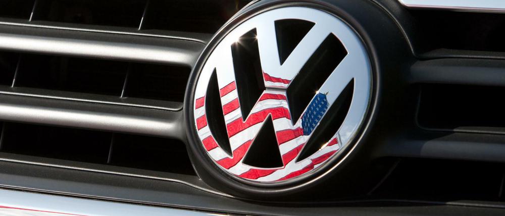 Die US-Fahne spiegelt sich in Logo und Kühlergrill eines Volkswagen-Fahrzeugs.