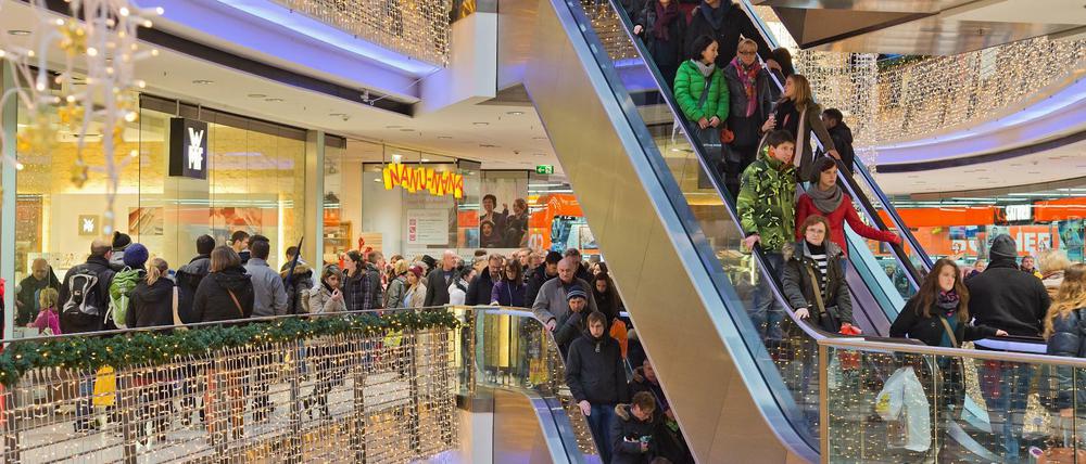 Passanten mit Weihnachtseinkäufen gehen am 14.12.2013 durch ein Einkaufszentrum auf der Königstraße in Stuttgart (Baden-Württemberg). 
