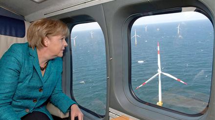 Je größer, desto besser. Das glaubt die Bundesregierung (hier Angela Merkel bei einem Hubschrauberrundflug über die Ostsee) und fördert Riesenwindräder auf See besonders großzügig. Die Branche will aber auch Riesen an Land genehmigt bekommen. Hier gibt es Streit.