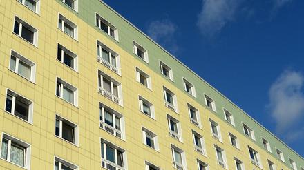 Ein Plattenbau in Berlin mit grün-gelber Fassade.