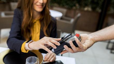 Wer mit dem Smartphone zahlen will, braucht es nur kurz ans Kartenlesegerät halten.