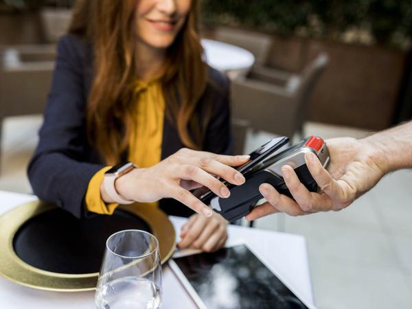 Wer mit dem Smartphone zahlen will, braucht es nur kurz ans Kartenlesegerät halten.