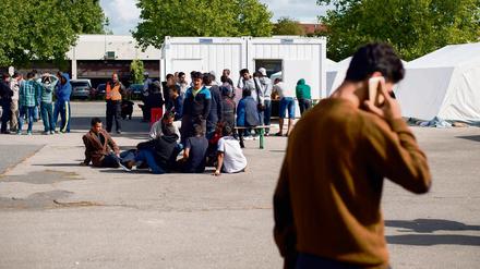 Junge Männer warten vor einem Container des Landesamtes für Gesundheit und Soziales um sich auf dem Gelände der Flüchtlingsunterkunft in der ehemaligen Schmidt-Knobelsdorf-Kaserne in Berlin registrieren zu lassen. 