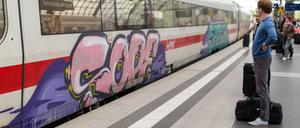 Kunst oder Vandalismus? Ein Passagier steht am Berliner Hauptbahnhof vor einem mit Graffiti beschmierten ICE.