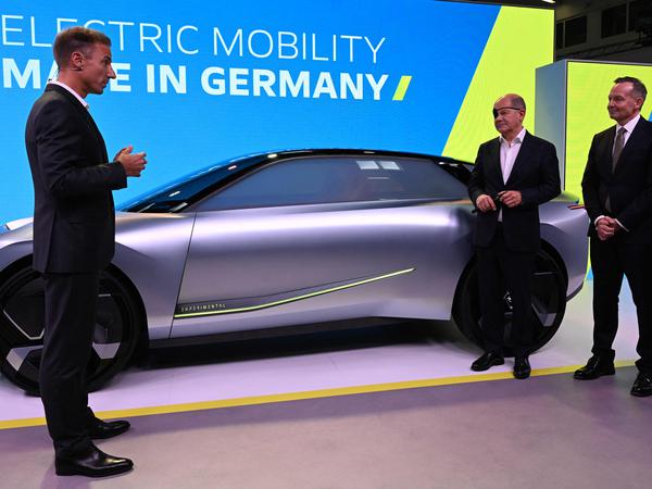 Bundeskanzler Olaf Scholz und Bundesverkehrsminister Volker Wissing hören dem Vorstandsvorsitzenden von Opel Deutschland, Florian Hüttl, neben einem Opel-Experimentalfahrzeug auf der IAA in München zu (Symbolbild).
