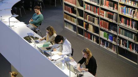 Studierende arbeiten in einer Unibibliothek.