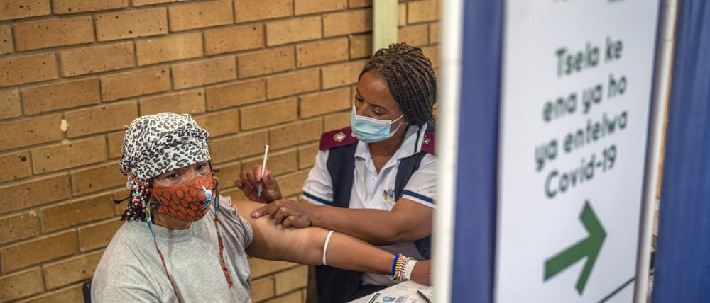 03.12.2021, Südafrika, Orange Farm: Eine Frau erhält im Mehrzweckzentrum von Orange Farm eine Corona-Impfung. Südafrika hat seine Impfkampagne eine Woche nach der Entdeckung der Omikron-Variante des Coronavirus beschleunigt. Die neue Coronavirus-Variante Omikron überrascht Wissenschaftler in Südafrika durch eine zunehmende Infektion auch von jungen Kindern. Foto: Jerome Delay/AP/dpa +++ dpa-Bildfunk +++