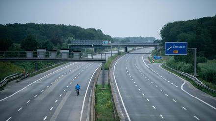 Ein Fahrradfahrer fährt über die gesperrte Autobahn A1 nahe Blessem in Erftstadt. +++ dpa-Bildfunk +++