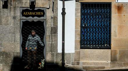 Ein Mann schließt sein Geschäft in Santiago de Compostela.