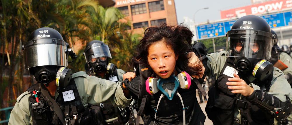 Eine Demonstrantin wird festgenommen, als sie versucht, den Campus der Polytechnischen Universität in Hongkong zu verlassen.