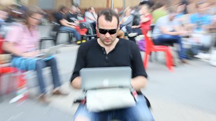 Ein Besucher der Internetkonferenz Re:publica mit seinem Laptop auf den Knien.