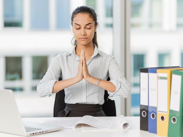 Im Büro kurz innehalten und den Körper spüren: Das hilft gegen Dauerstress im Job.