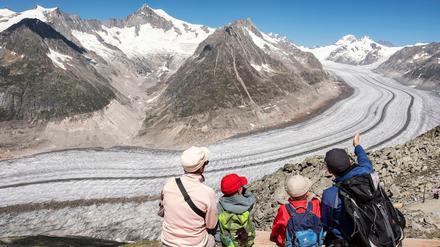 Wanderer blicken auf den Großen Aletschgletscher, den größten und längsten Gletscher der Alpen.