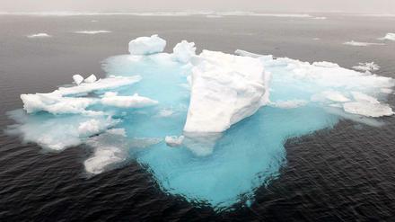 Ein Eisberg und Eisschollen in der Arktis.