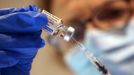 Eine Arzthelferin zieht eine Spritze mit einem Corona-Impfstoff aus.