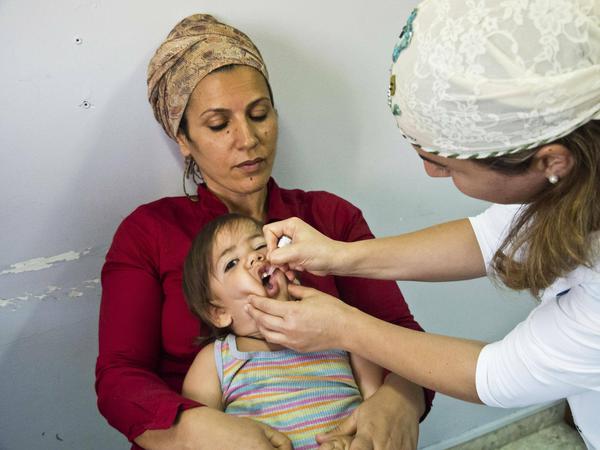 Ein Kind wird in Jerusalem mit einer Schluckimpfung gegen Polio geimpft. 