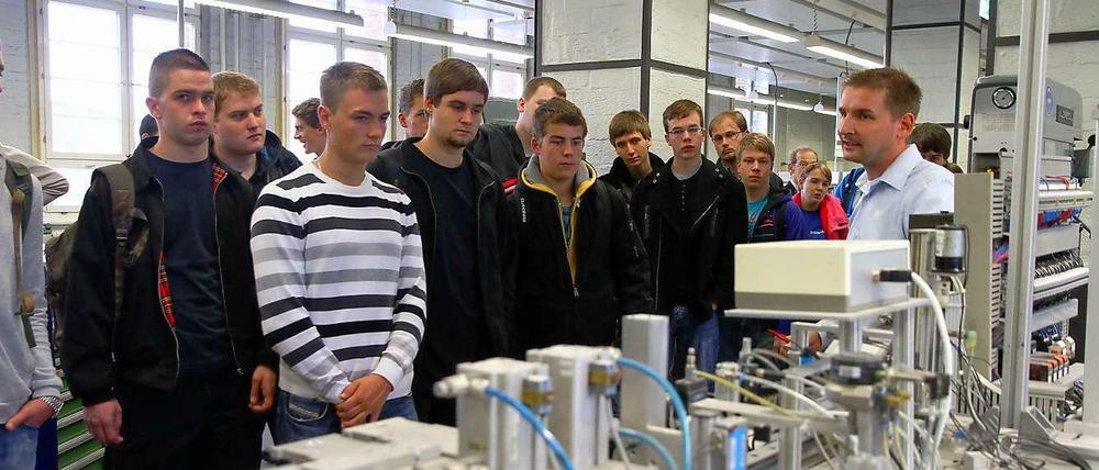 Junge Männer schauen sich eine Ausbildungswerkstatt bei Siemens an.